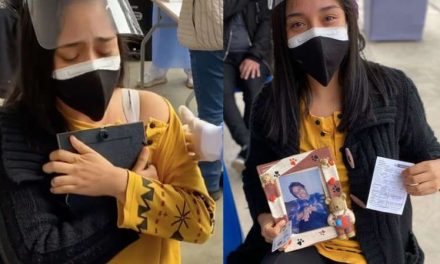 Joven llora al recibir vacuna mientras abraza la foto de su madre fallecida por covid (video)